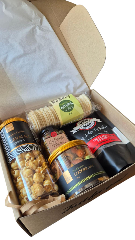 Box of snacks including a can of nuts, a jar of cookies, and a bag of chips.