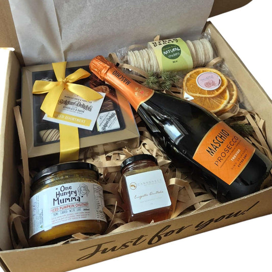 Gift box with champagne, snacks, and other items on a white background
